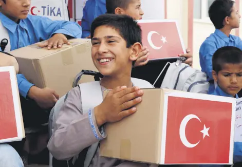  ??  ?? Children hold the boxes of gifts delivered to orphans by Turkey’s TİKA in Mazar-i-Sharif, Afghanista­n, May 12, 2021.