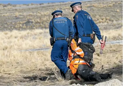  ?? JOHN BISSET/STUFF ?? Police drag a protester away from a Greenpeace demonstrat­ion at Simons Pass Station in the Mackenzie Country yesterday.