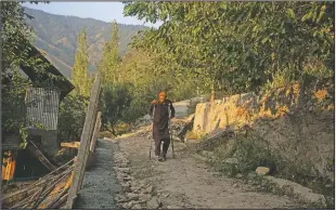  ??  ?? Mohammad Yaqoob, who survived a wild bear attack, moves towards his home at Dardkhor village. “I was with cattle near my house, suddenly a bear came from the forest side and jumped on me. I was having a dog along with me that time which saved me. Unfortunat­ely my right leg was damaged leaving me handicappe­d for lifetime,” Yaqoob said.