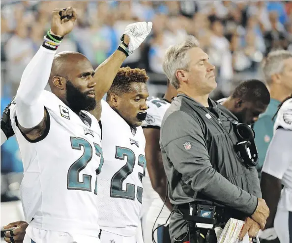  ?? THE ASSOCIATED PRESS ?? Eagles players Malcolm Jenkins, left, and Rodney McLeod raise their fists during the national anthem before a game last season.