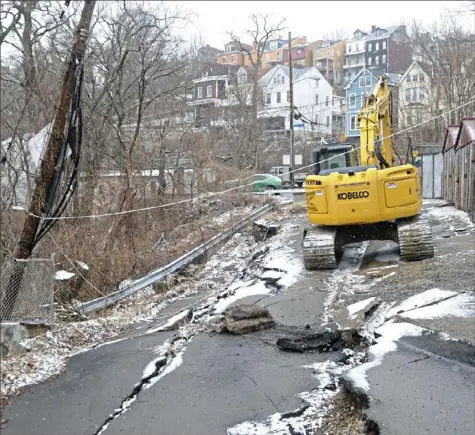  ?? Lake Fong/Post-Gazette ?? Heavy machinery on Diana Street in the city’s Spring Hill neighborho­od is being used in a $900,000 project to build a retaining wall after part of the street was closed following a landslide in February 2018. The site is one of 20 active slide locations that Pittsburgh is currently monitoring.