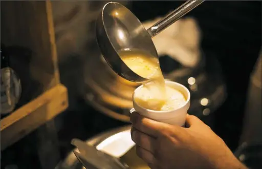  ??  ?? Bierport general manager Theo Ackerson ladles hot Butterbeer, a Harry Potter-inspired concoction, during a two-week festival celebratin­g the J.K. Rowling books and movies in Lawrencevi­lle.