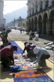  ?? GIOVANNA DELL’ORTO VIA AP ?? People creating a colored sawdust carpet in the main square of Antigua, Guatemala on the morning of the city’s first Easter season procession. Miles of the cobbleston­e streets are covered in sawdust and flower carpets that take up to 12 hours to create...