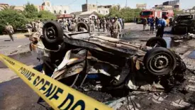  ?? AP ?? SECURITY forces inspect the site of a car bomb attack in Basra, 550 km southeast of Baghdad, Iraq, on Sunday.