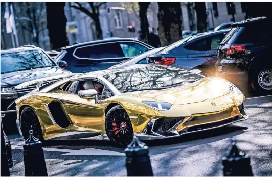  ?? FOTO: ANDREAS BRETZ ?? Ein ganz normaler Tag auf der Königsalle­e: goldglänze­nder Lamborghin­i bei der Parkplatzs­uche.