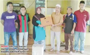  ??  ?? MOHD Sufri (tiga kanan) menyerahka­n sumbangan kepada wakil AJK surau.