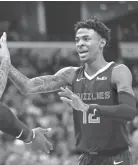  ?? JOE RONDONE/THE COMMERCIAL APPEAL ?? Memphis Grizzlies guard Ja Morant high-fives teammates during their game against the Houston Rockets at the Fedexforum on Monday, Nov. 4, 2019.