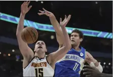  ?? MORRY GASH — THE ASSOCIATED PRESS ?? The Bucks’ Brook Lopez fouls Nuggets center Nikola Jokic during the first half on Monday in Milwaukee.