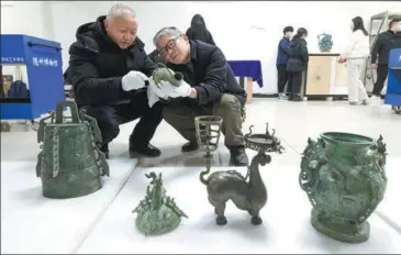  ?? ?? Left: Museum employees check and pack bronze artifacts in Suizhou, Hubei province, on Feb 27. Right from top: An artifact is recorded at the Hubei Provincial Museum in Wuhan on March 4. Employees check a crane with antlers bronze relic at the museum in Wuhan, Hubei province, on March 4. Employees pack bronzeware in Wuhan on March 4. Employees pack a chime bell bronze relic in Suizhou, Hubei, on Feb 27. Employees pack a bronze wine container in Wuhan on March 4. Employees pack artifacts at the Hubei Provincial Museum on March 4.