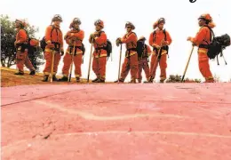  ?? Noah Berger / Associated Press ?? Inmate firefighte­rs prepare to take on the River Fire in Salinas last month. California has been ravaged by record wildfires this year.