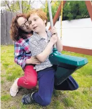  ?? STEVEN SENNE/ASSOCIATED PRESS ?? Susan Grenon, left, plays with her son Pauly in the backyard of their home in Smithfield, R.I., on May 11. Grenon’s son cannot bring a bottle to school to reapply sunscreen without a doctor’s note.