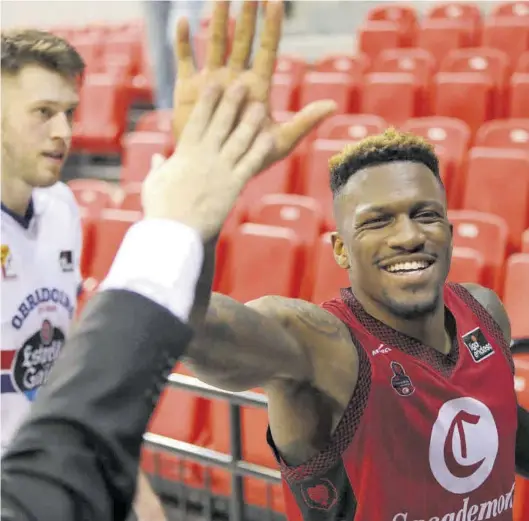  ?? ÁNGEL DE CASTRO ?? Dylan Ennis choca la mano para celebrar el triunfo de ayer frente al Obradoiro.