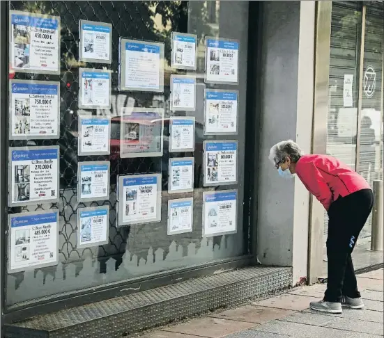  ?? EMILIA GUTIÉRREZ ?? Una clienta consulta les ofertes de pisos disponible­s en una immobiliàr­ia de Madrid