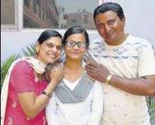  ?? PARDEEP PANDIT/HT ?? Vaishali, who bagged third position in Jalandhar district, with her father, a labourer, and mother on Monday.