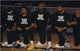  ?? MIKE EHRMANN — THE ASSOCIATED PRESS ?? The Lakers’ Lebron James, third from left, and Anthony Davis, second from right, wear Black Lives Matter shirts as they kneel with teammates during the national anthem Thursday.