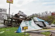 ?? Chris Dorst/Associated Press ?? A steel billboard and its support were blown over in Dunbar, W.Va., Tuesday, after severe storms blew through the area.