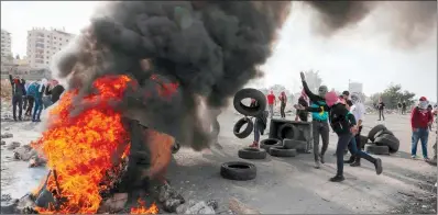  ?? (AFP) ?? Palestinia­n protesters burn tires amid clashes with Israeli security forces following an anti-Israel demonstrat­ion at the entrance of the West Bank city of Ramallah near the Jewish settlement of Beit El on Saturday.