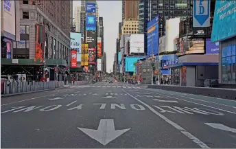  ?? — AFP file photo ?? A car approaches on a nearly empty street near Times Square in New York City.