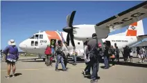  ??  ?? People exit a U.S. Coast Guard plane during the Pacific Coast Dream Machines Show at Half Moon Bay Airport.