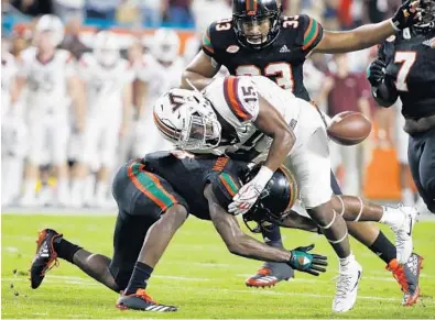  ?? WILFREDO LEE/AP ?? Miami defensive back Jaquan Johnson, here forcing a fumble, had 96 tackles and four intercepti­ons from the safety position last season. Despite the possibilit­y of the NFL beckoning, Johnson says he has unfinished business with the ’Canes.