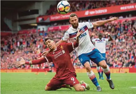  ?? EPA PIC ?? Liverpool’s Roberto Firmino (left) is challenged by Stoke City’s Erik Pieters at Anfield yesterday.