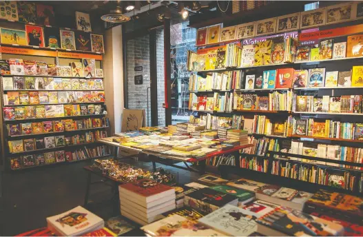  ?? MAURICIO MOLIZANE DE SOUZA/GOSH! COMICS ?? Tables and bookcases at Gosh! Comics in Soho are piled high with titles and genres from traditiona­l superhero fare to children’s comics.