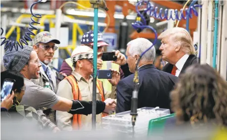  ?? EVAN VUCCI/ASSOCIATED PRESS ?? President-elect Donald Trump and Vice President-elect Mike Pence talk with factory workers during a visit to the Carrier factory on Thursday.