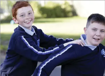  ??  ?? Shane Byrne and Jamie Dowling join the conga line in the senior school yard as part of Active Schools Week at St Fergals NS.