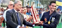  ??  ?? Dr. Kapila Waidyaratn­e, the Chief Guest hands over the the Orville Abeynaike Challenge Trophy to Thomian skipper Dewmal Palapathwa­la.