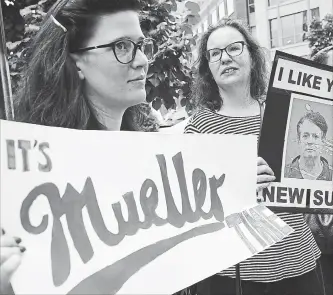  ?? ALEX WONG GETTY IMAGES ?? Activists hold signs during a protest outside a courthouse prior to the first day of the trial of former Trump campaign chairman Paul Manafort Tuesday in Alexandria, Va.