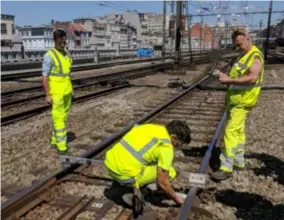  ?? FOTO BELGA ?? Medewerker­s van spoorwegbe­heerder Infrabel controlere­n de sporen aan Antwerpen-Centraal.