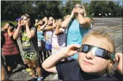  ?? CHARLIE RIEDEL — THE ASSOCIATED PRESS ?? Fourth-graders at Clardy Elementary School in Kansas City, Missouri, practice the proper use of their eclipse glasses in anticipati­on of Monday’s solar eclipse.