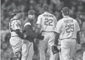  ??  ?? Dodgers manager Dave Roberts (second from left) relieves pitcher Clayton Kershaw on Tuesday night.