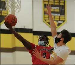  ?? KEN SWART — FOR MEDIANEWS GROUP ?? Caleb Banks (0) of Southfield A&T lays in two of his 10points as Rochester Adams’ Brady Prieskorn (20) defends during the OAA White match-up played on Friday, February 19, 2021at Adams High School.