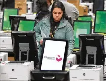  ?? CURTIS COMPTON / CCOMPTON@AJC.COM ?? A worker helps test and pack a new voting machine last month. As of Monday, 105 of Georgia’s 159 counties had received their touchscree­ns, according to a court filing.