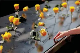  ?? ANDREW KELLY / REUTERS ?? Flowers are placed alongside the names of 9/11 victims, at the National September 11 Memorial & Museum, a month before the 20th anniversar­y of the attacks.