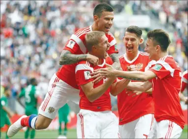  ?? The Associated Press ?? Russia’s Yuri Gazinsky celebrates with teammates after scoring his side’s first goal against Saudi Arabia during a Group A match to open the 2018 World Cup at the Luzhniki stadium in Moscow, Russia, on Thursday. Russia won 5-0.