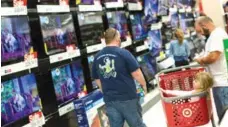  ?? THE ASSOCIATED PRESS/JOHN MINCHILLO ?? A child rests in a shopping cart in the electronic­s section against a backdrop of television­s at a Target store, Friday in Newport, Ky.