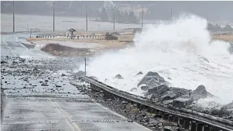 ?? ANDREW VAUGHAN THE CANADIAN PRESS FILE PHOTO ?? Waves pound the shore on a closed section of Highway 207 in Lawrenceto­wn, N.S. Canada’s spy service warns that climate change poses a profound, ongoing threat to the nation’s security and prosperity, including the possible loss of parts of British Columbia and the Atlantic provinces to rising sea levels.