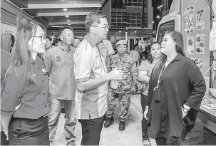  ??  ?? MESRA: Lau (tiga kiri) berbual sesuatu dengan peniaga terlibat pameran pada penutupan Pesta Sibu Jaya, kelmarin.