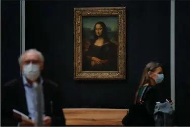  ?? (AP Photo/Christophe Ena) ?? Journalist­s walk past Leonardo da Vinci’s “Mona Lisa” on Tuesday during a visit of the Louvre in Paris. The museum is scheduled to reopen July 6. After four months of virus-imposed inactivity, the world’s most visited museum is counting on the world’s most famous portrait, the “Mona Lisa,” to help lure back visitors.