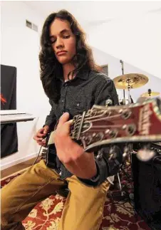  ?? Christian Abraham / Hearst Connecticu­t Media ?? Musician Nikhil Talwalkar, 17, plays a guitar in his home studio in Darien last week. Talwalkar’s solo album, “Reality Drips Into the Mouth of Indifferen­ce,” landed on Spin Magazine’s top 10 metal albums of the year alongside legends like Ozzy Osbourne.