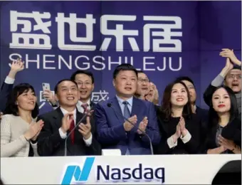  ?? JUDY ZHU / CHINA DAILY ?? Zheng Wei (center), chairman and CEO of SSLJ.com Ltd, rings the opening bell to celebrate his company’s initial public offering on the Nasdaq Stock Market in New York on Monday. SSLJ provides home-improvemen­t services in China.