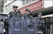  ?? AP/BURHAN OZBILICI ?? Riot police stand guard as hundreds of people queue Tuesday in front of Turkey’s Supreme Electoral Board in Ankara. Petitioner­s were requesting the electoral authority reverse a decision to accept ballots without official stamps.