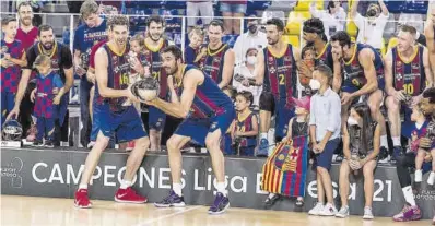  ?? Europa Press ?? Oriola y Pau Gasol, con su hija en brazos, levantan el trofeo de Liga conquistad­o por el Barça.