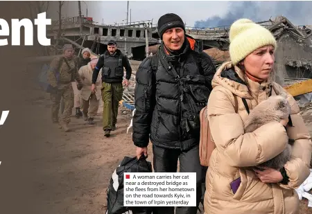  ?? ?? A woman carries her cat near a destroyed bridge as she flees from her hometown on the road towards Kyiv, in the town of Irpin yesterday