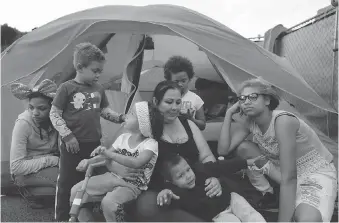  ??  ?? Christine Wade plays with her children in front of their tent in the city-sanctioned encampment in a San Diego parking lot. They are, from left, Shawnni, 12, Roland, 4, Rayahna, 3, Jaymason, 2, Brooklyn, 8, and Shaccoya, 14.