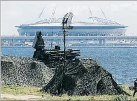  ?? ANTON VAGANOV / REUTERS ?? Todos los frentes. Lanzadora de misiles antiaéreos apostados cerca de San Petersburg­o, con el estadio de la ciudad al fondo