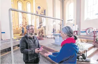  ?? FOTO: MARK HILDEBRAND­T ?? Der Tettnanger Pfarrer Rudolf Hagmann testet mit Mesnerin Angela Jauk die Plexiglass­cheibe, die bei der Kommunion das Infektions­risiko minimieren soll.