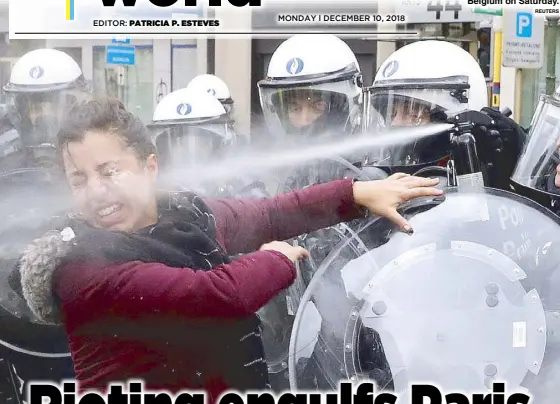  ??  ?? BELGIUM, TOO: A woman is sprayed with tear gas by the riot police officer during the ‘yellow vests’ protest against higher fuel prices in Brussels, Belgium on Saturday.